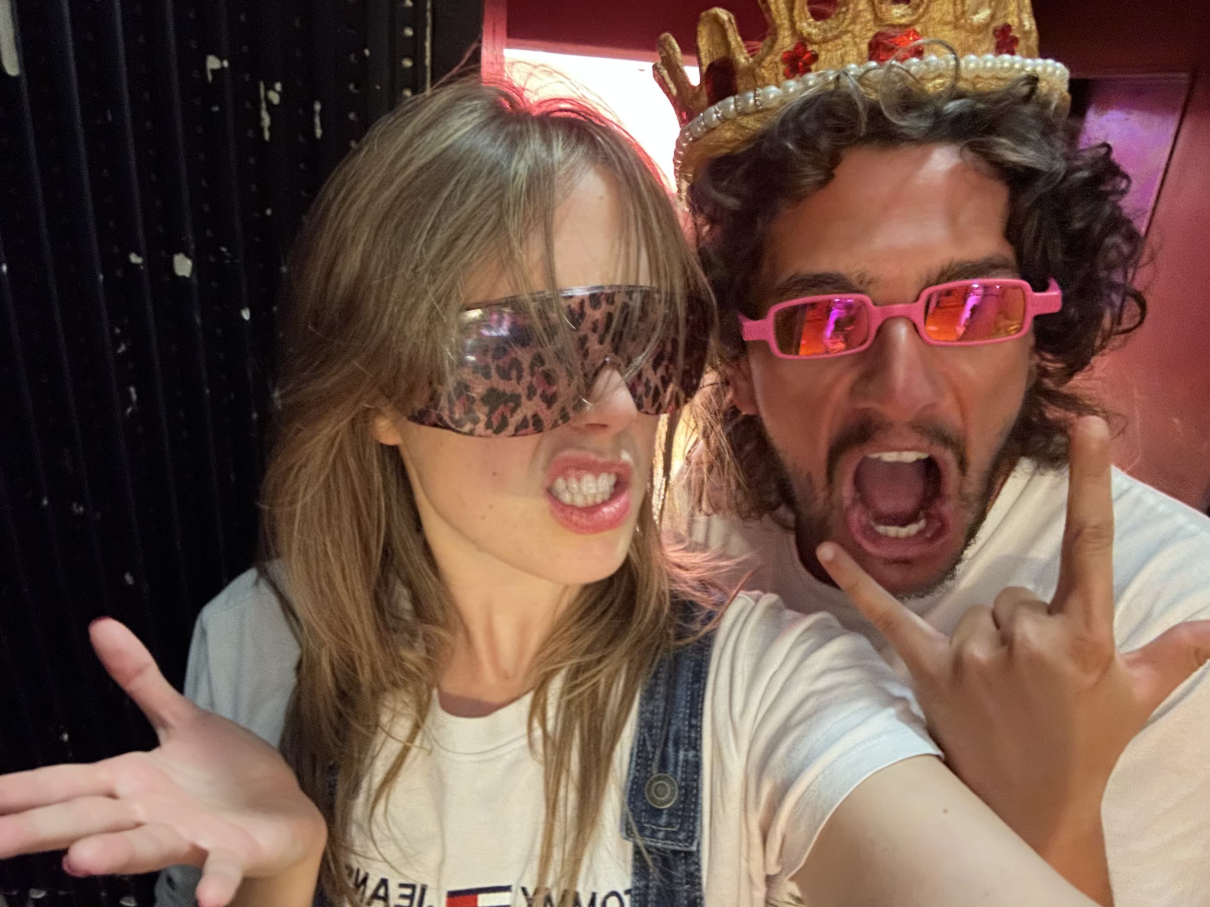 Two people wearing playful glasses and posing for a photo